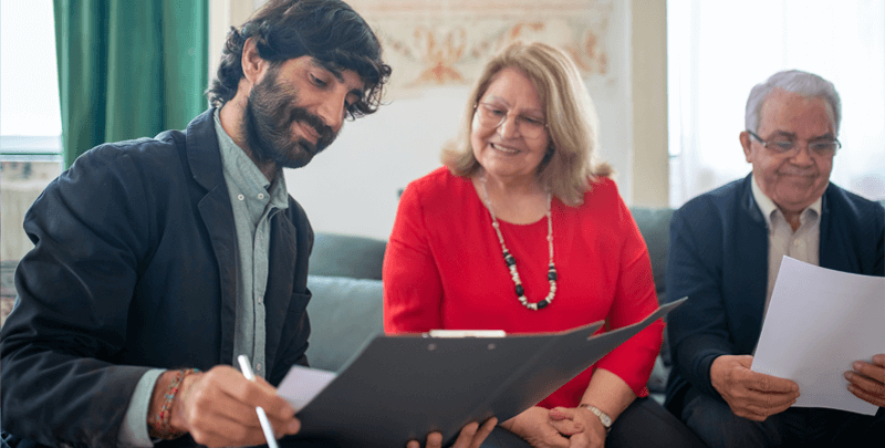 Profissionais de consultoria tributária analisando documentos em escritório.