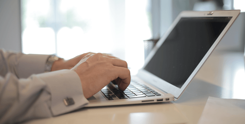 Computador portátil com pessoa digitando, representando serviços de tecnologia e eficiência empresarial da Dootax.