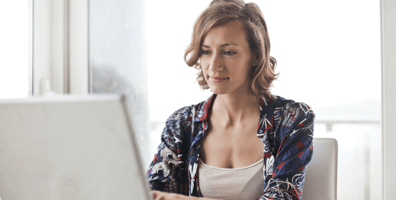 Profissional feminina trabalhando com tablet em ambiente de escritório com grande janela de vidro ao fundo, transmitindo produtividade, inovação e tecnologia.