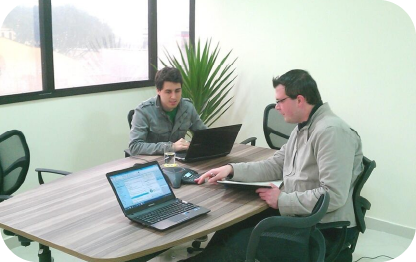 Profissionais de contabilidade em reunião de trabalho, focando em serviços de consultoria tributária e soluções financeiras, com laptops em ambiente corporativo.